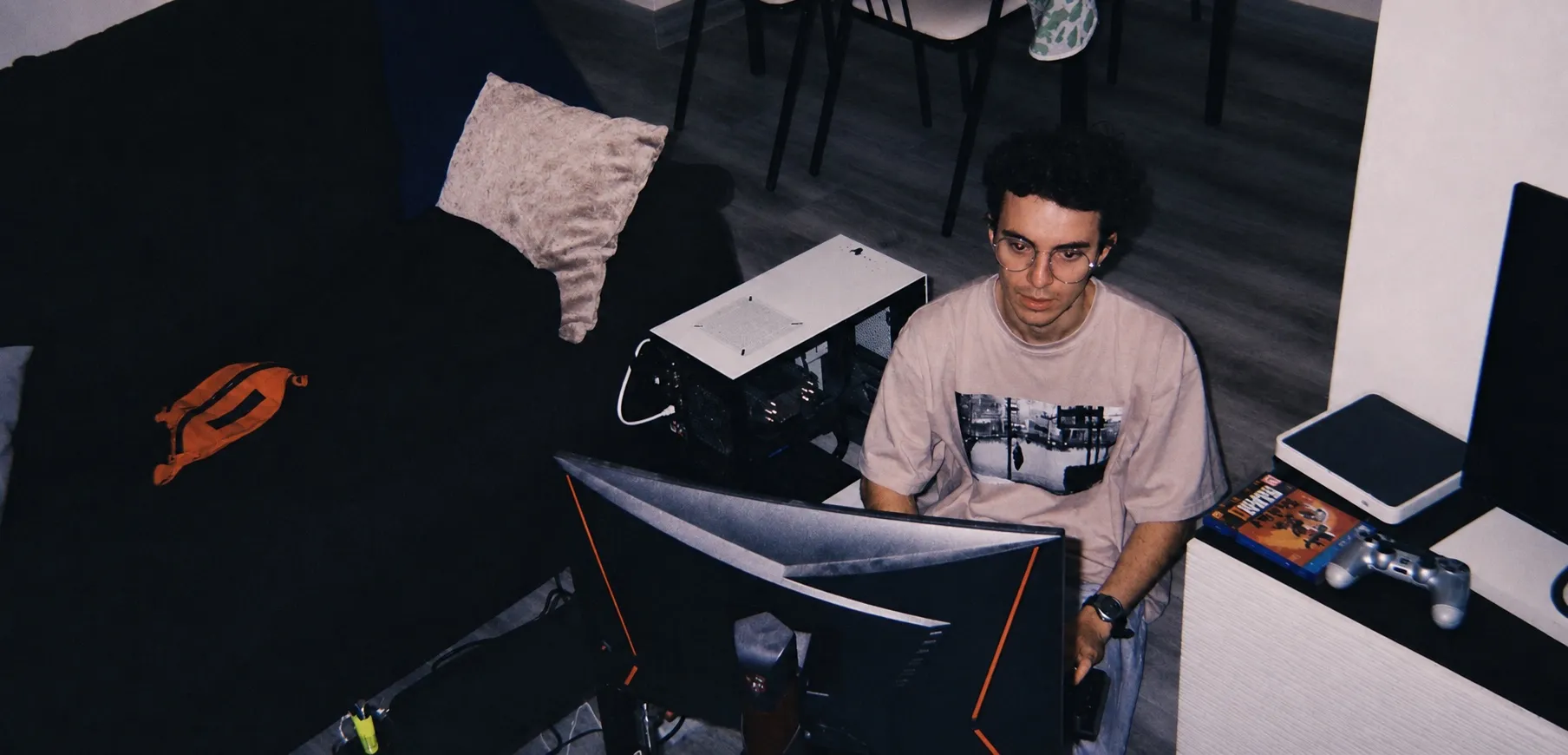 Iñigo at his desk, working at a two-monitor setup with an open PC case beside him